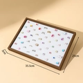 Black walnut wood grain jewelry tray with white sponge lining and various colorful rings - 100 Slots Ring Tray