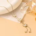 Detail of 18K gold butterfly necklace with white mother of pearl on a marble tray - Shell Butterfly (Gold Style 7)
