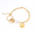 Dettaglio del bracciale a catena dorata con una grande perla bianca e diversi ciondoli tondi - Bracciale con placca tonda di perle / Oro