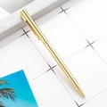 Sleek gold metal ballpoint pen with slim clip on minimalist grid paper background - Cross Style Electroplated Gold