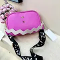 Detail of pink lychee leather crossbody bag with white zigzag flap and wide strap - Rose Red