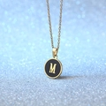 Elegant gold round pendant necklace with black enamel inlay and gold letter M design - Letter M