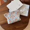 Détail d'une trousse à fleurs avec accessoires en dentelle sur un plateau en bois - Petites Fleurs Jaunes Plissées sur Fond Beige