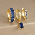 Macro shot of three gold drop earrings set with deep blue zircon stones on luxury gold base - Three-Piece Set / Gold-Blue Zirconia