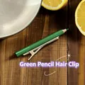 Détail d'une pince à cheveux créative en forme de crayon vert avec clip doré - Vert