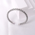Detailed view of silver braided stainless steel cuff bracelet on white silk texture - Steel 5