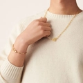 Detailed view of 18k gold handcuff pendant necklace and bracelet set on a model - Gold Bracelet + Necklace