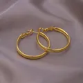 Polished minimalist golden hoop earrings set displayed on soft silk fabric background - E-066---Gold 30mm