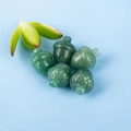 Cinco colgantes de jade verde en forma de bellota sobre fondo azul claro limpio - Aventurina Verde