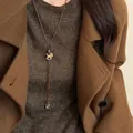 Vintage Holz Schaukelpferd Anhänger Halskette auf braunem Pullover für Herbst - Holz Schaukelpferd Braunes Seil Stil
