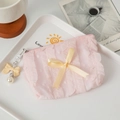 Detailed shot of pink ruffle makeup bag with yellow ribbon bow and pearl charm - Pink