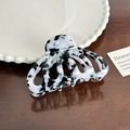 Large marbled acetate hair claw clip with black and white hollow design on wood surface - Black and White Marble Pumpkin Claw