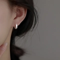 Brushed S925 sterling silver hoop earrings in matte silver finish on a model ear - 12mm / Silver