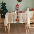 Detailed embroidery of Christmas bells and bows on a high-quality beige lace tablecloth - Christmas Candle Bell