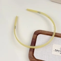 Détail d'un serre-tête jaune en acétate avec dents antidérapantes sur fond blanc épuré - Jaune-vert