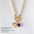Elegant pearl necklace featuring a gold heart clasp, blue gemstone, and engraved disk charm - Letter Q