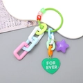 Close-up of colorful acrylic heart and star keychains with letter beads and plastic chain - Green