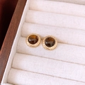 Macro view of vintage round resin earrings with golden wheat pattern borders in jewelry box - Round Style
