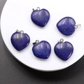 Lapis lazuli heart pendants with silver bails on stone display platform - Dyed Lapis Lazuli