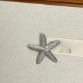 Detailed macro view of silver starfish brooch with embossed dotted texture on linen - 26 Silver Starfish (Z-4599)