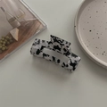 Detail view of a large rectangular marble-pattern acetate hair claw on a decorative tray - Large Square Claw / Black & White