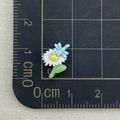 Detailed macro view of a 1.2cm resin daisy and dragonfly charm on a CM scale grid - Dragonfly White Daisy