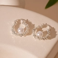 Dettaglio di orecchini a cerchio in argento con perle bianche su un piedistallo elegante - Ear Cuff Perla Argento Frammentato