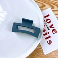 Detail of large matte navy blue square hair claw clip on an aesthetic plate setting - Blue