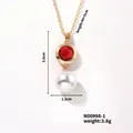 Elegante collana a catena dorata con cristallo rosso sfaccettato e pendente in perla bianca - Zirconia Rossa + Perla