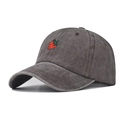 Detail showing washed grey cotton fabric and red strawberry embroidery on baseball cap - Coffee