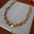 Détail d'un collier multicouche en perles de pierre naturelle sur présentoir en velours - Café (Plaqué or véritable)