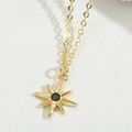 Macro detail of gold starburst necklace featuring a black central gemstone on white leather - Black Zirconia (Gold)