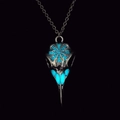 Macro shot of Viking raven skull necklace with luminous blue patterns on dark background - Antique Silver Light Blue Glow