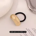 Golden irregular metal ponytail holder with textured surface and black elastic rope - Arched Fish Scale Gold