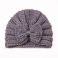 Detail of grey baby knitted hat featuring a cute bow and warm wool texture close-up - Gray