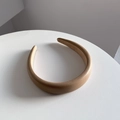 Vista superior de una diadema ancha acolchada de cuero PU beige sobre mesa blanca - 3CM de ancho / Caqui