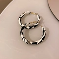 Dettaglio di orecchini a cerchio in pelle a C con motivo geometrico astratto bianco e nero - Perno in Argento S925 Intrecciato Bianco e Nero (Piccolo)