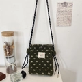 Close-up of olive green plush crossbody bag with white heart pattern and braided strap - Green Heart