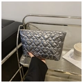 Silver quilted heart clutch bag with metallic glossy finish held in hand, fall fashion style - Gray