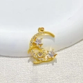 Gold moon and star pendant with sparkling cubic zirconia on a white textured background - Crescent Moon & Two Stars