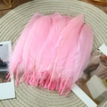 Detailed view of soft pink goose feathers on a woven mat for DIY craft projects - Stiff Pink (50Pcs)