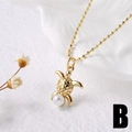 Dettaglio della collana con pendente a tartaruga dorata e perla su sfondo in ceramica - Tartaruga marina / Oro