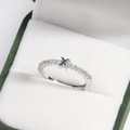 Detailed macro of a silver diamond X-shape ring inside a green velvet jewelry box - Platinum X