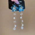 Details von blauen Kristallblumen-Ohrringen mit Perlen und goldenen Quasten - Silbernadel Blumenquaste / Blau
