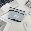 Dettaglio della borsa cosmetica in denim con design patchwork e bordo sfrangiato verde - Blu Chiaro Fiocco
