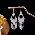 Detail of silver ethnic tassel earrings with geometric cutouts on a wooden branch - Silver Geometric Hollow Long Tassel Style (E2873-30)