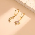 Asymmetric gold moon and star hoop earrings with pink crystal stones in a lifestyle shot - Gold with Pink Zirconia