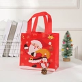 Close-up of red non-woven Christmas gift bag with Santa and penguin prints on white desk - 23x22x11cm / Red