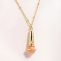 Macro shot of gold microphone pendant with textured pink finish on a stainless steel chain - Orange