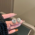 Orecchini a perno halo con zircone ovale in argento tenuti in mano per le dimensioni - Forma Ovale / Argento
